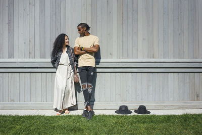 Couple talking while leaning on wall