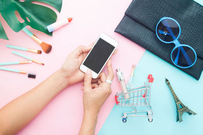 Midsection of person using mobile phone on table