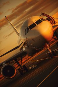 Close-up of airplane on airport runway against sky