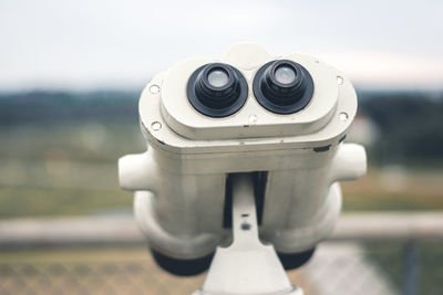 Close-up of coin-operated binoculars against sky