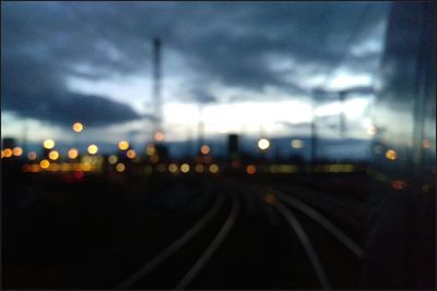 Close-up of illuminated railroad tracks against sky at night