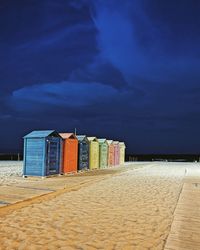 Beach huts by sea against blue sky