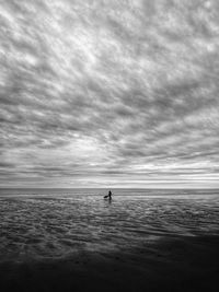 Silhouette people on beach against sky