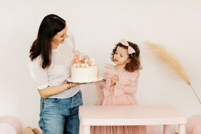 Side view of young woman using mobile phone while sitting on table