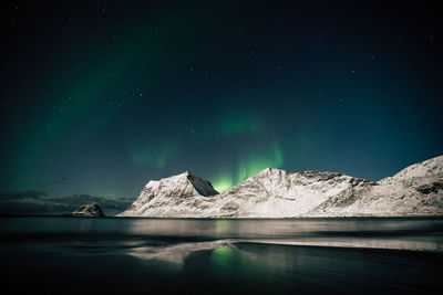 Scenic view of snowcapped mountains against sky at night