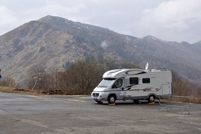 Scenic view of mountains against sky with camper