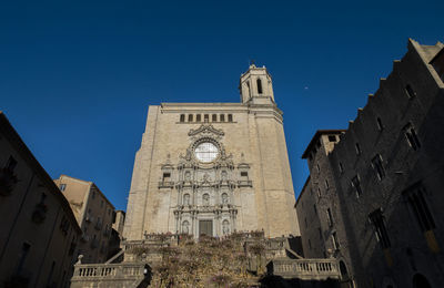 Low angle view of buildings against clear blue sky