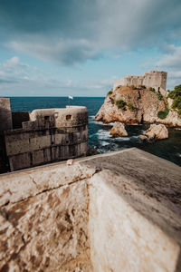 Rocks by sea against sky