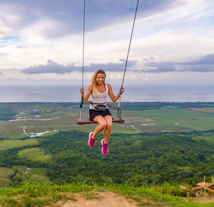 A woman swings on a swing on a high mountain in the dominican republic. tourist place. 