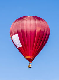 Low angle view of hot air balloon against clear blue sky