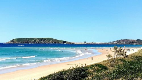 Scenic view of beach against clear blue sky