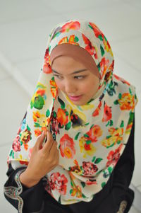 Teenage girl wearing headscarf while standing indoors