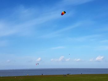 Parachute over sea against sky
