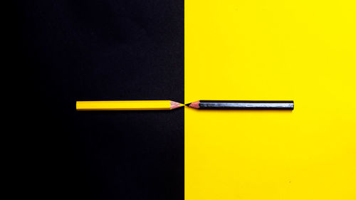 Directly above shot of yellow pencils against colored background