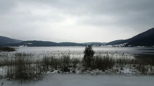 Scenic view of lake against sky during winter