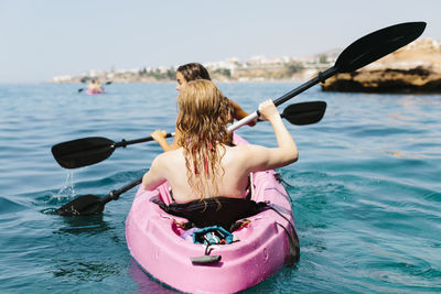 Rear view of woman in boat against sea