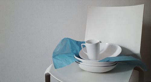 Close-up of coffee cup on table against wall at home