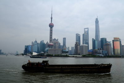 Boat sailing on river against shanghai world financial center in city