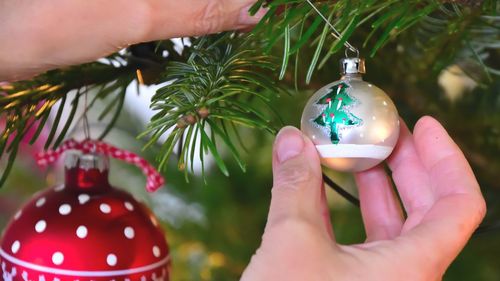 Close-up of woman holding christmas bauble