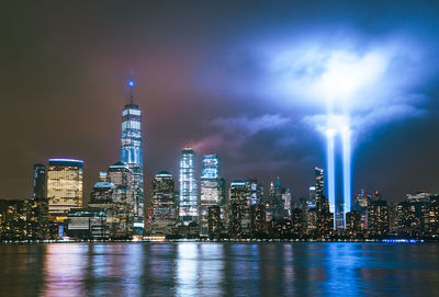 Illuminated buildings in city against sky at night