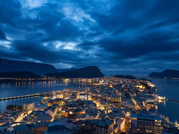 Illuminated cityscape against sky at night