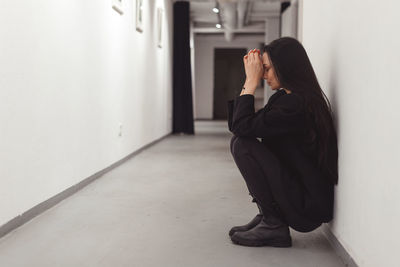 Side view of depressed woman in corridor