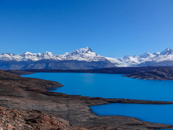 Scenic view of snowcapped mountains against blue sky