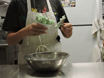 Midsection of man holding ice cream in bowl