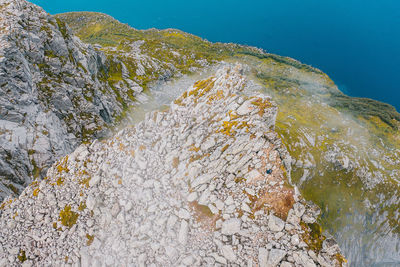 High angle view of rocks by sea against mountain