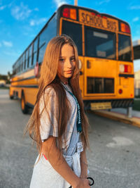 Portrait of young woman standing in city