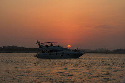 Boat in sea against sky during sunset