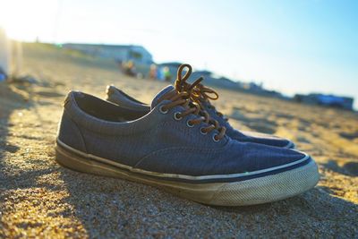 Close-up of shoes on sand