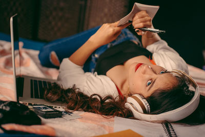 Portrait of teenage girl using pen and notebook at home