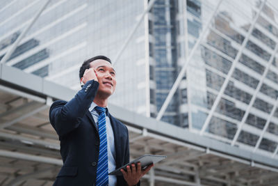 Full length of man using mobile phone in city