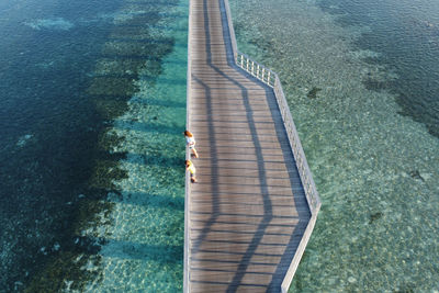 Mother and son looking at the ocean from a walkway in the maldive islands