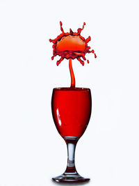 Close-up of red wine in glass against white background