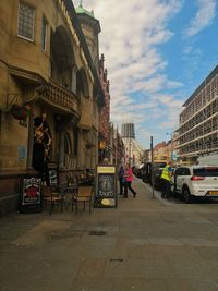 Cars on street against buildings in city