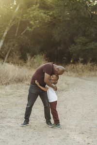 Happy father and son hugging in backlit field