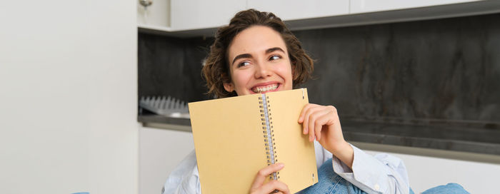 Portrait of young woman reading book