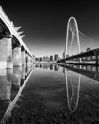 Bridge over river against clear sky at night