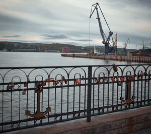 Close-up of suspension bridge against cloudy sky