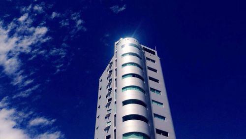 Low angle view of modern building against blue sky