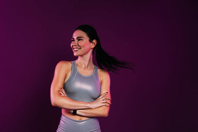 Young woman standing against gray background