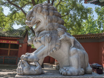 Statue against trees and building