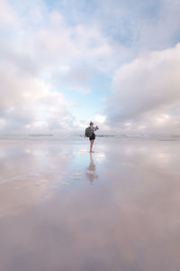 Rear view of man walking on beach