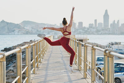 Woman standing on railing with cityscape in background