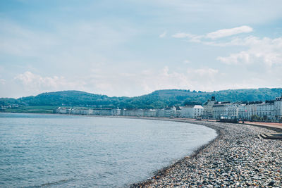 Scenic view of beach by city against sky