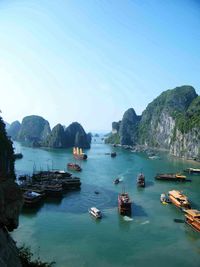 Boats moored in sea against clear sky