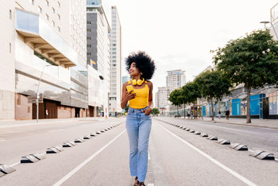 Portrait of young woman standing in city