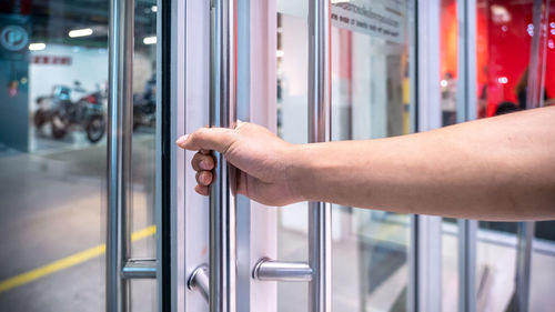 Close-up of hand on metal door